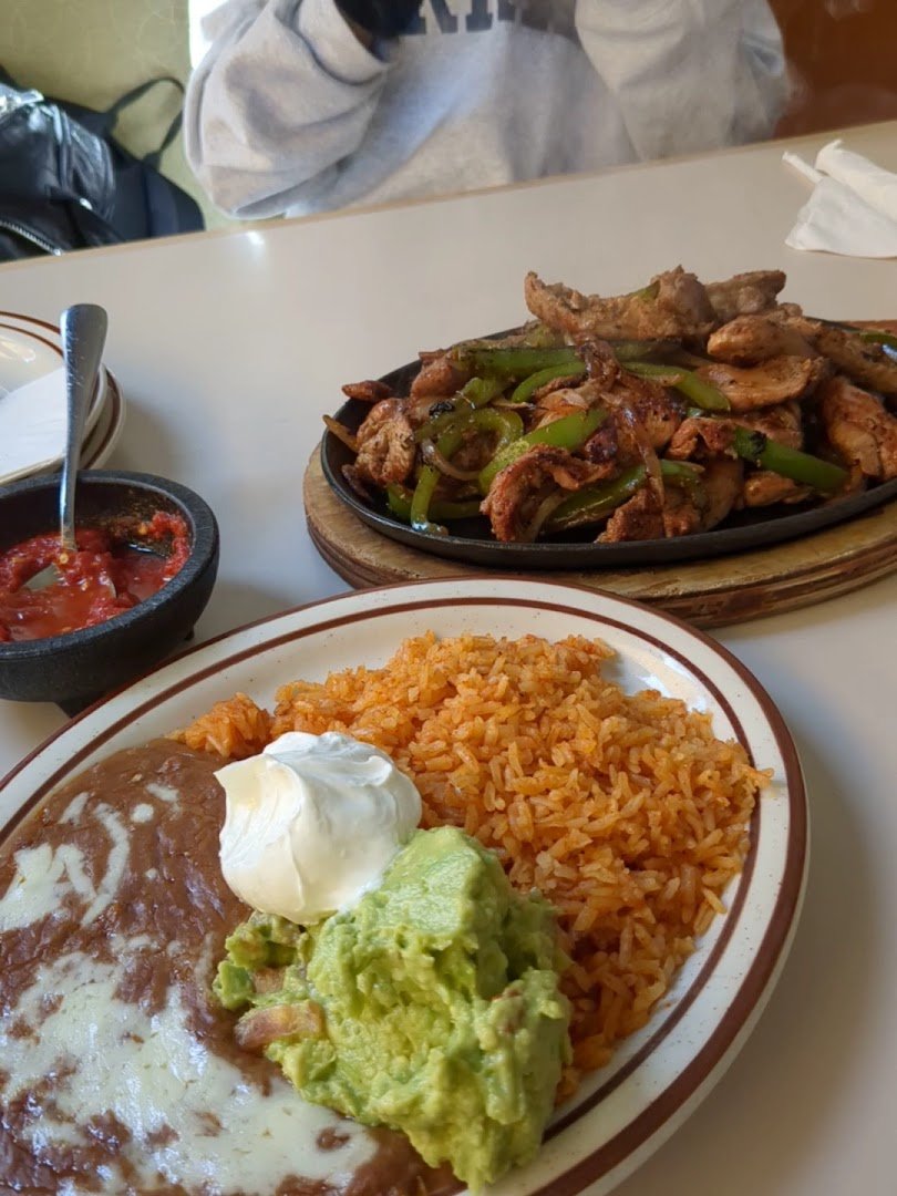 Outdoor seating beside a Mexican restaurant entrance.